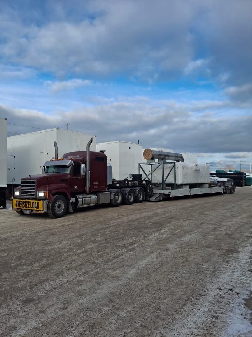 Lowboy with oversize wrapped industrial freight