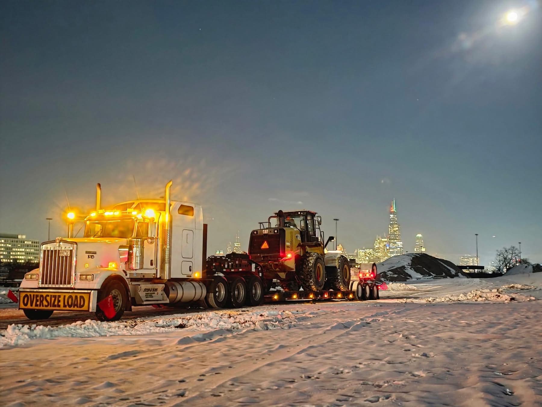 Lowboy with Caterpillar loader at night