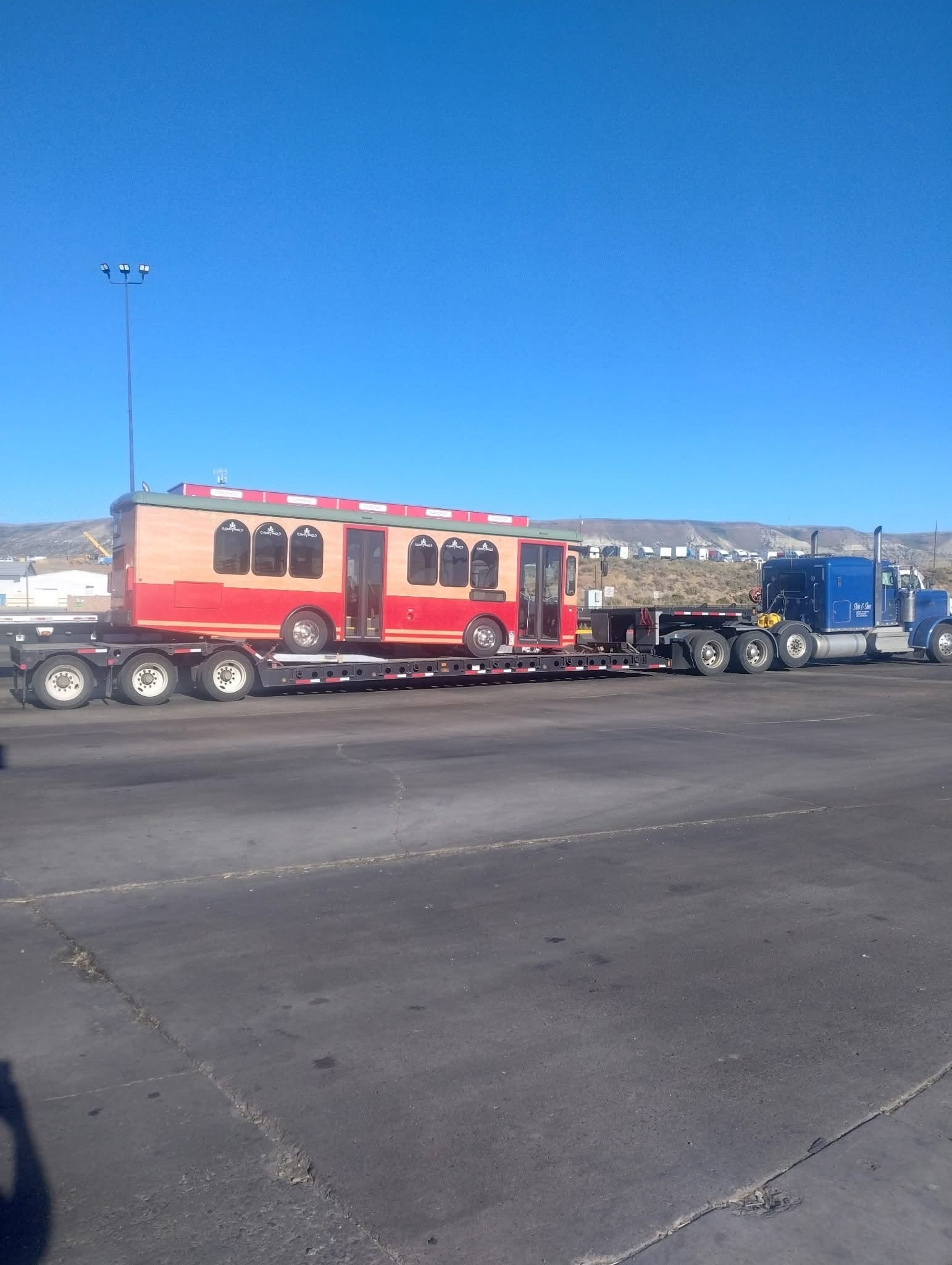 Stein & Sons blue truck hauling a trolley on lowboy